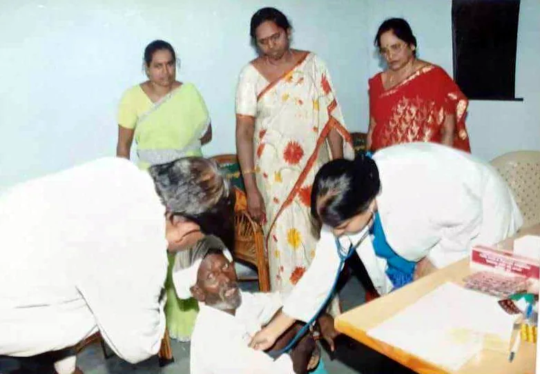 A doctor examining an elderly man at a KSS camp